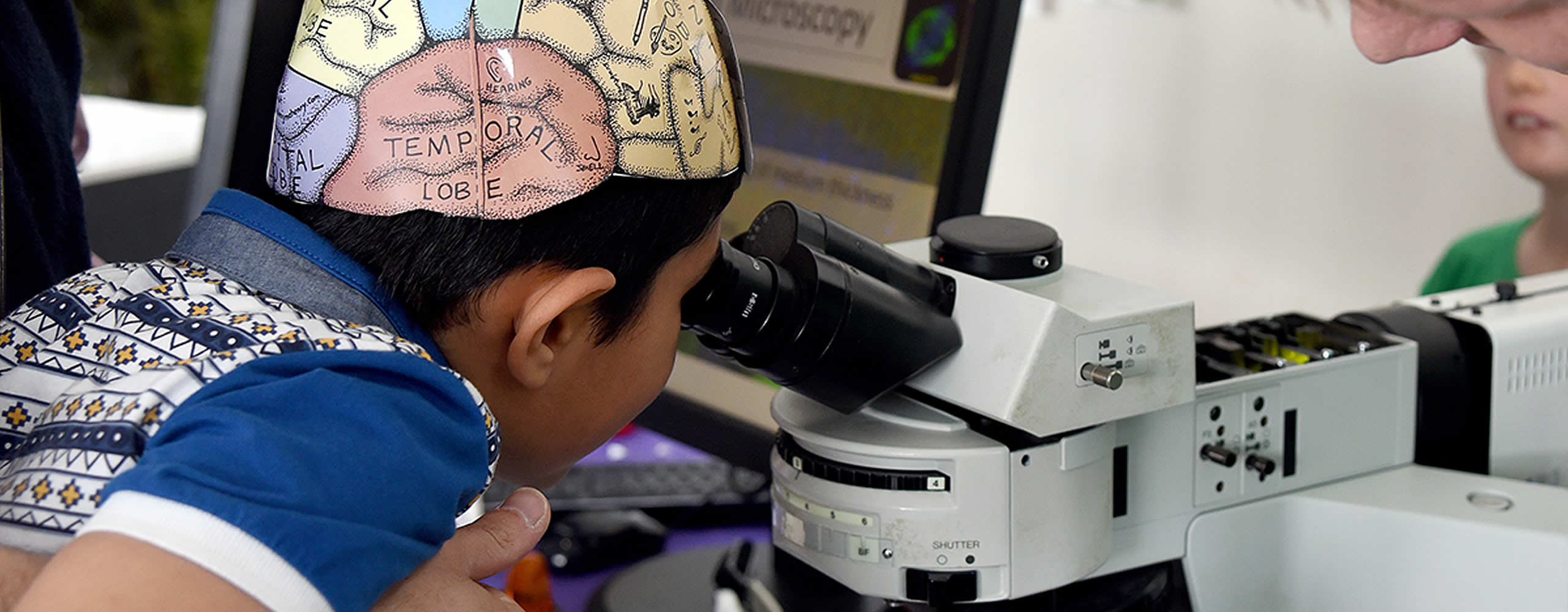 A young visitor takes a look down a microscope